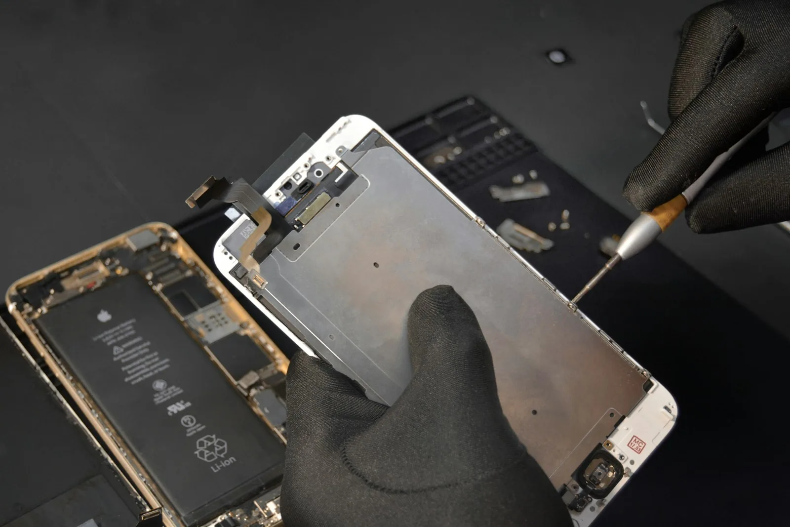 A technician replacing a phone screen at the bench