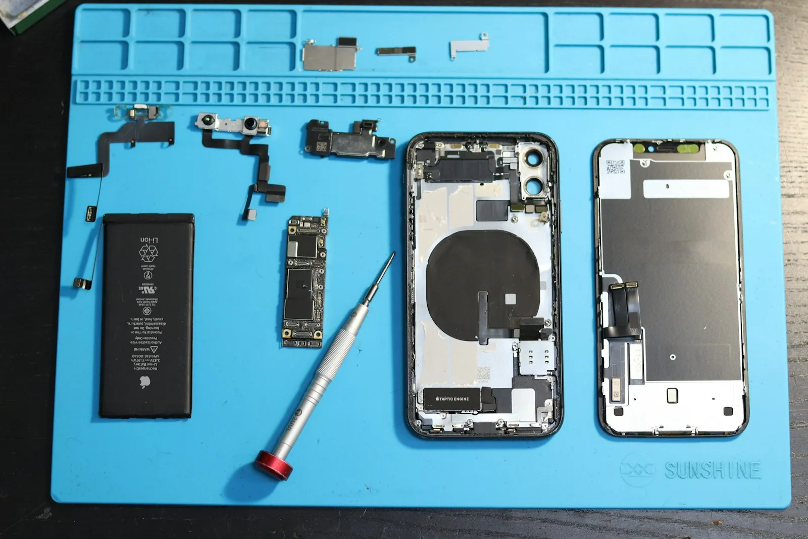 iPhone opened on a blue repair mat